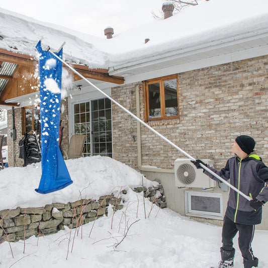 The garden tool being used to clear snow from a roof