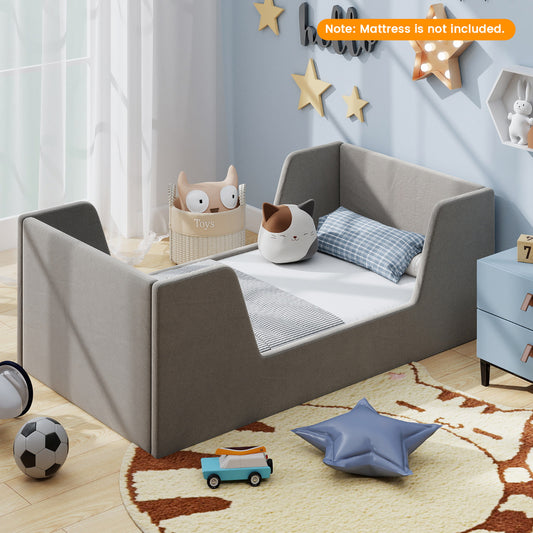 The grey upholstered children's floor bed with high sides and a slatted base