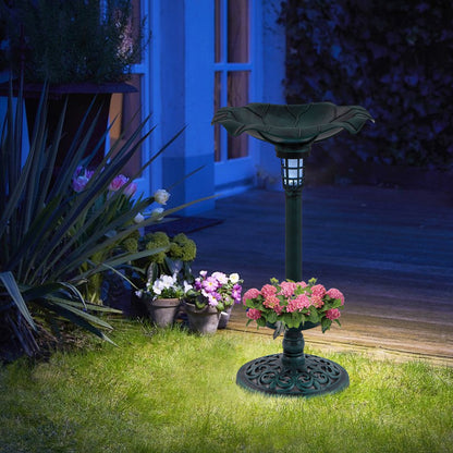 The bird bath and feeder set at dusk, with a soft light illuminating the garden
