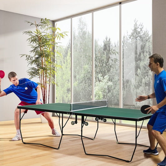 Two men playing tennis on a green folding table in a room