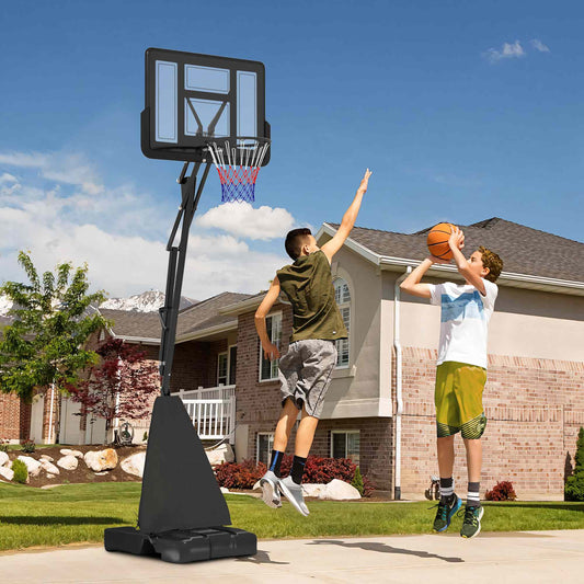 Two boys playing basketball with the adjustable hoop and stand in a garden setting