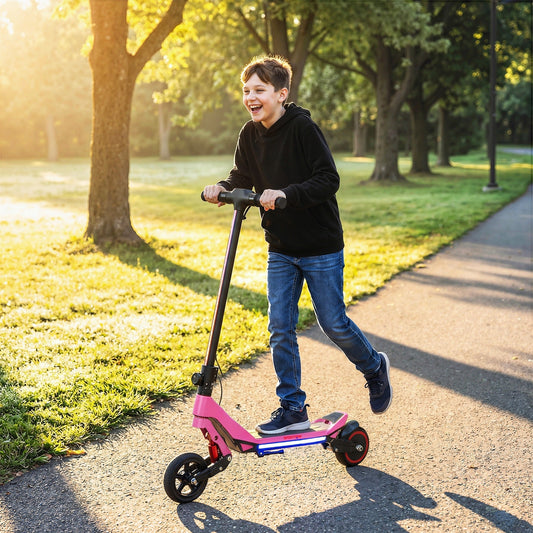A happy boy riding the pink electric scooter for kids down a sunny park path