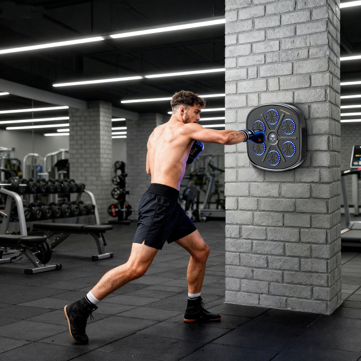 Man boxing against the wall mounted music boxing machine in a gym setting