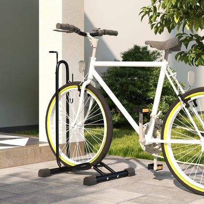 The black metal bicycle storage stand holding a white bike upright in a garden setting