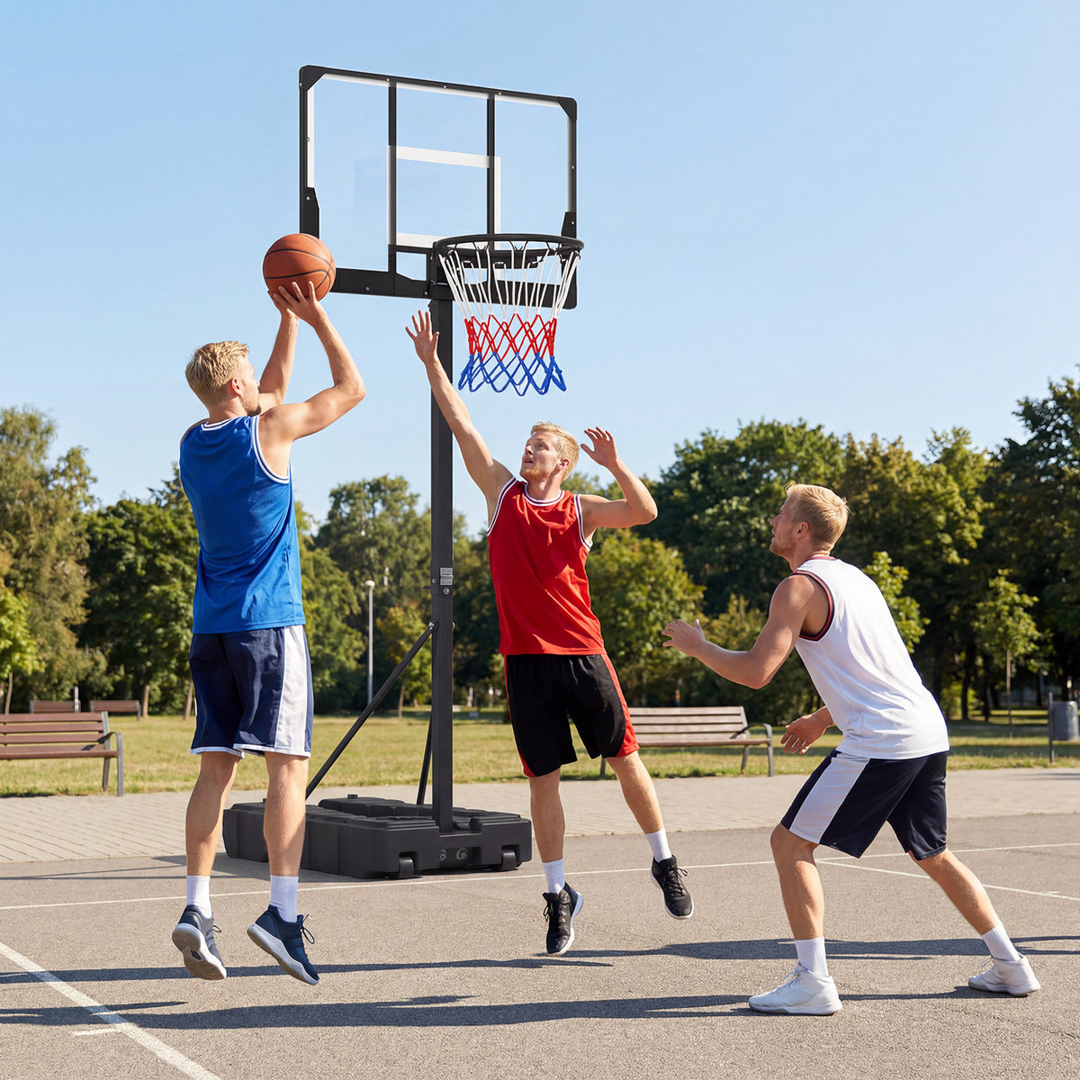 The basketball hoop standing on an outdoor court with three men playing a match