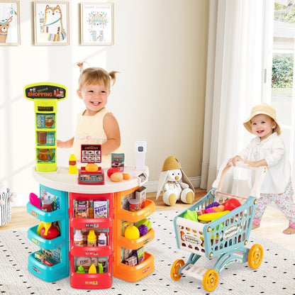 The play kitchen set in a bright room with two children playing with the trolley and shop