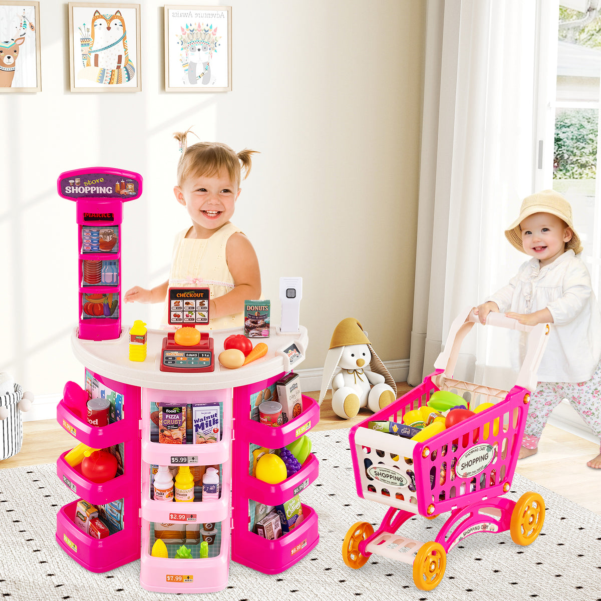 Two young children playing with the pink grocery store set in a bright living room