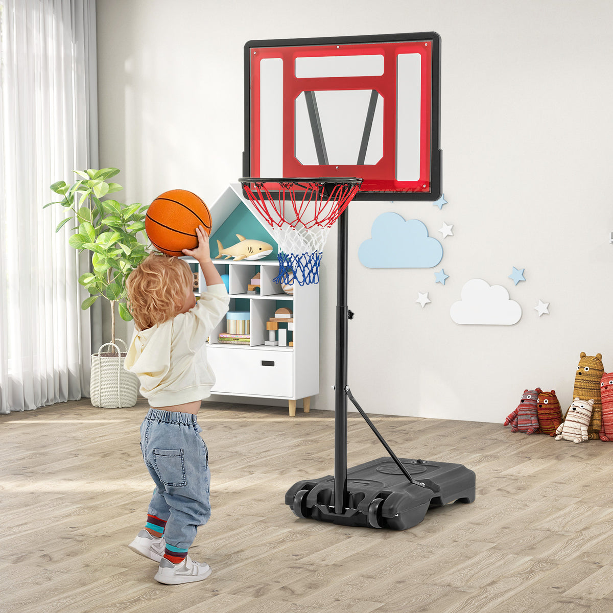 The sport equipment standing in a child's bedroom while a toddler plays with a basketball