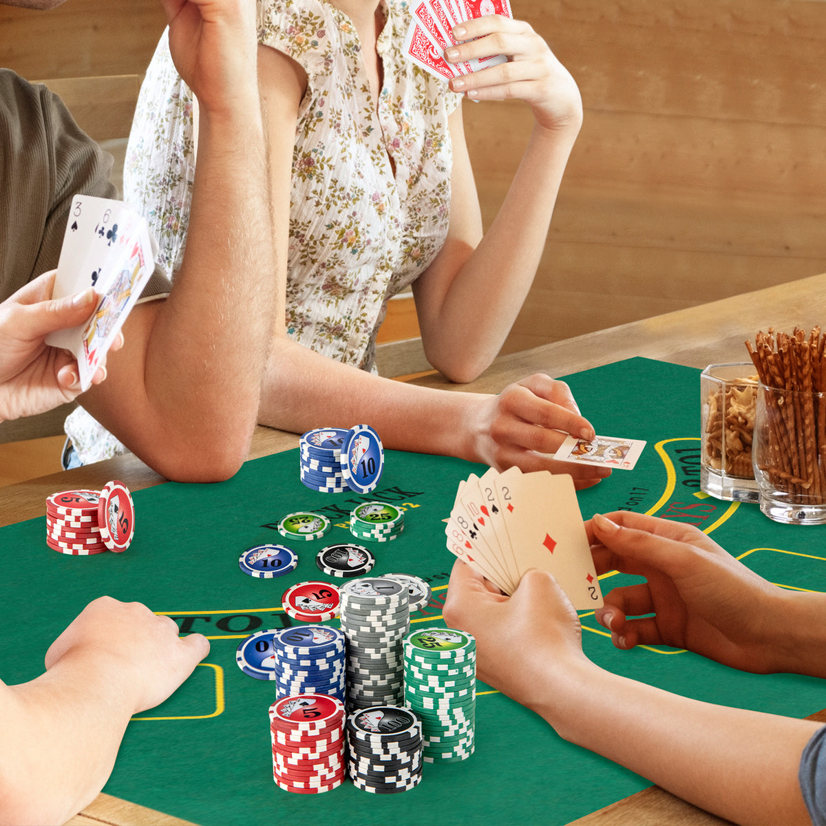 People playing poker at a green felt table with stacks of chips and cards
