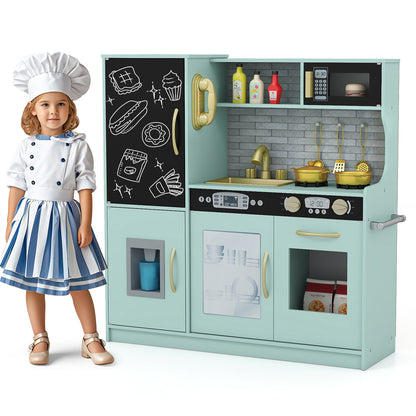 Young girl in chef outfit standing by the green pretend kitchen set with accessories