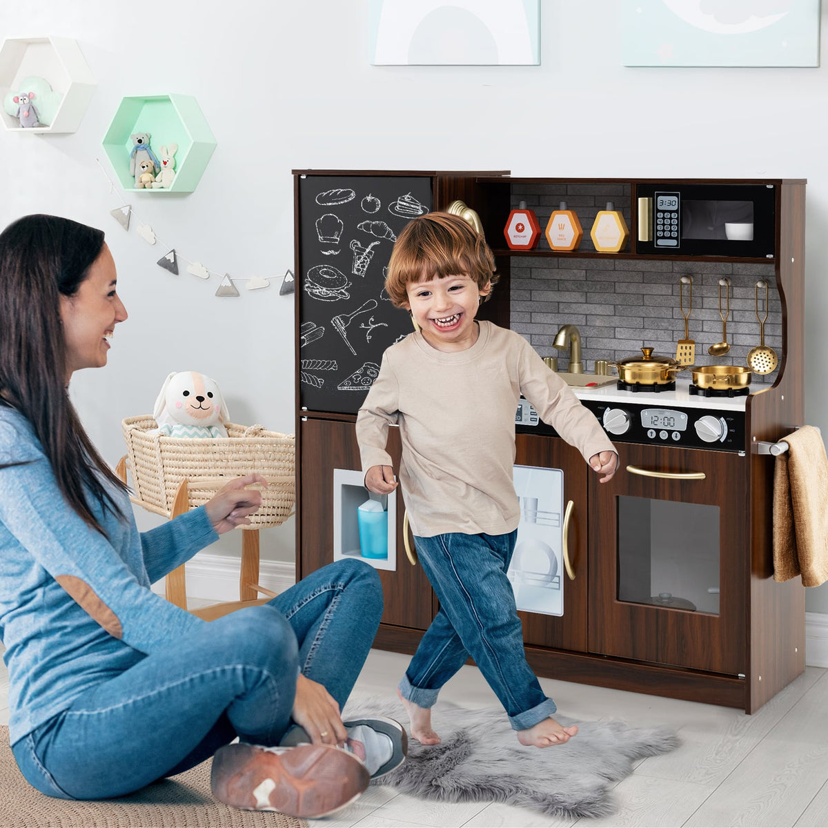 The play kitchen set in a bright nursery room with a happy child playing near his mother