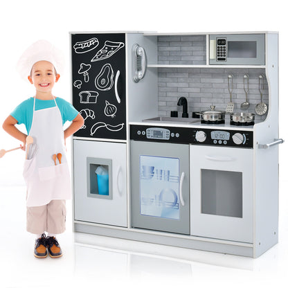 A young boy dressed as a chef standing next to the white play kitchen set on a white background