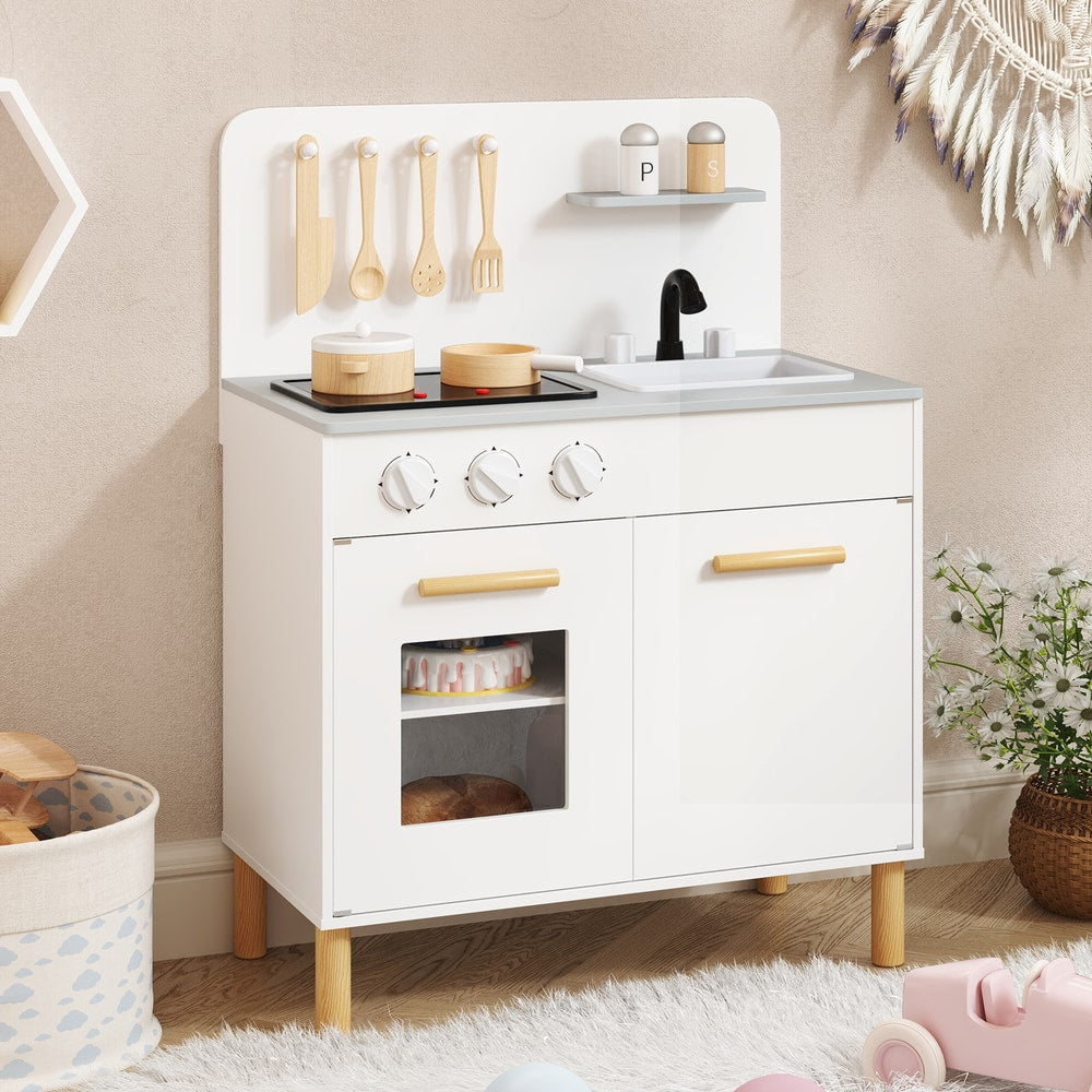 White play kitchen set with wooden utensils and cooking pots on a shelf