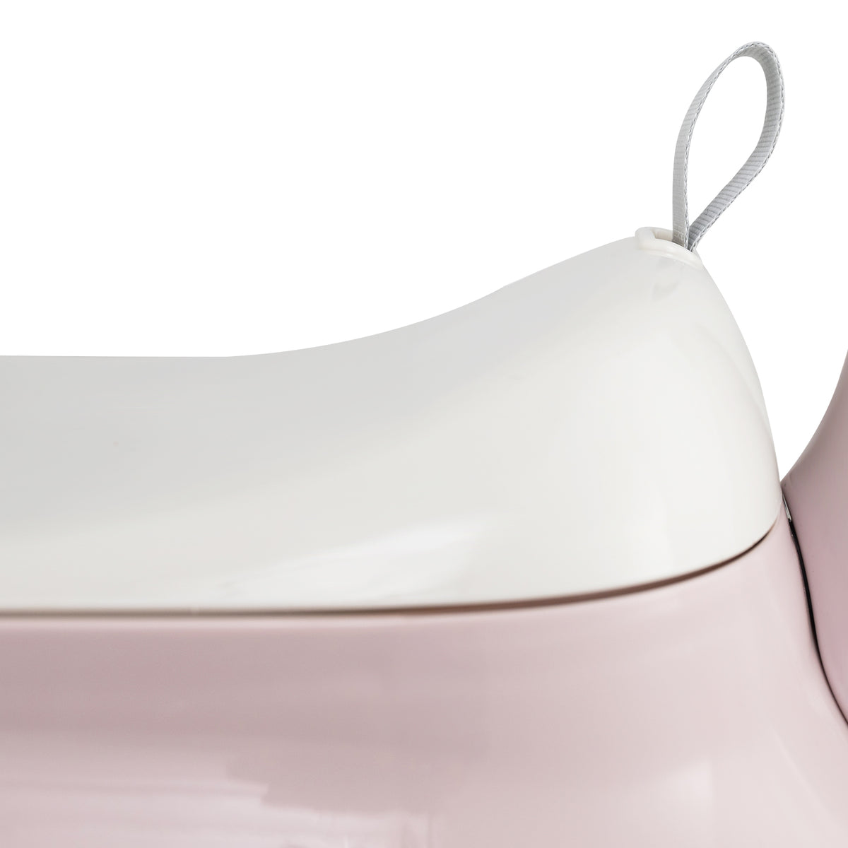 Close up of the white seat lid on the pink push & pedal ride on toy