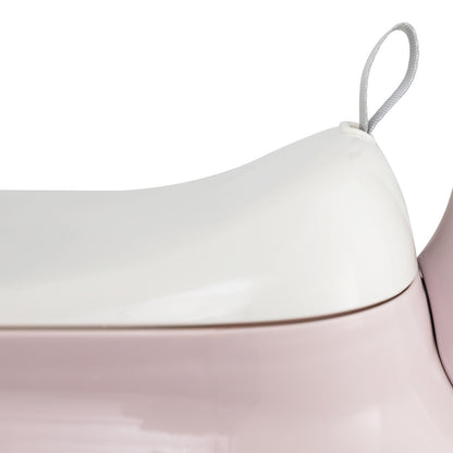 Close up of the white seat lid on the pink push & pedal ride on toy