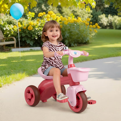 The pink ride on toy with a bell and basket on a paved path in a garden