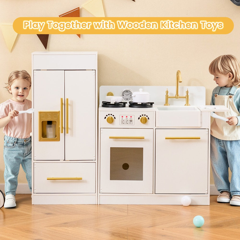 Two toddlers interacting with the white toy kitchen playset, one holding a spoon