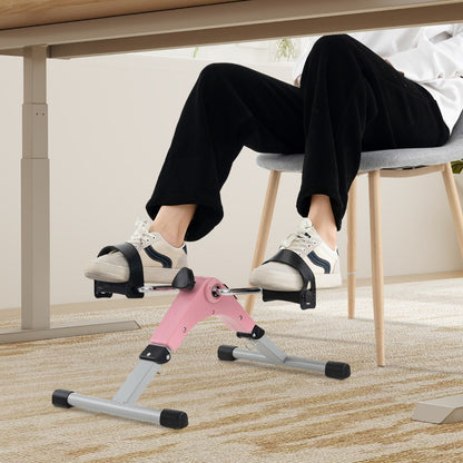 The exercise bike positioned under a desk with a person using it for leg training