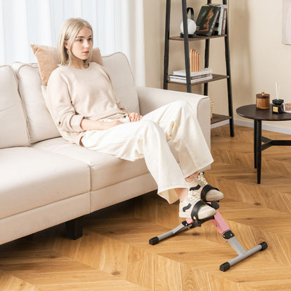 The exercise bike placed on a wooden floor in front of a sofa for leg exercise