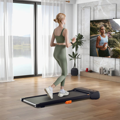 A slim walking treadmill in a bright living room with a woman exercising on it
