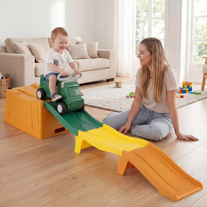The ride on toy being used by a toddler in a living room with a woman watching