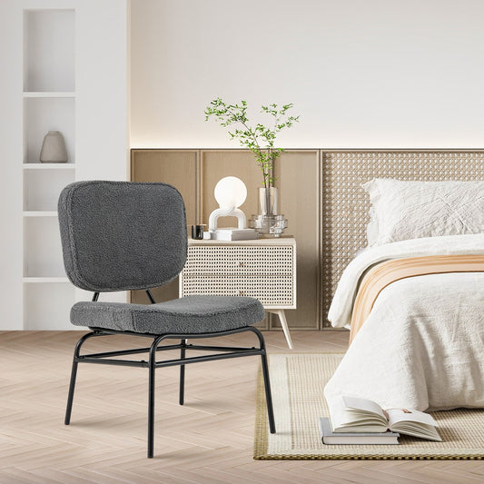 The grey accent chair is placed in a bedroom setting next to a bed