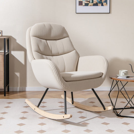 The beige corduroy glider rocker is shown in a living room setting with a side table