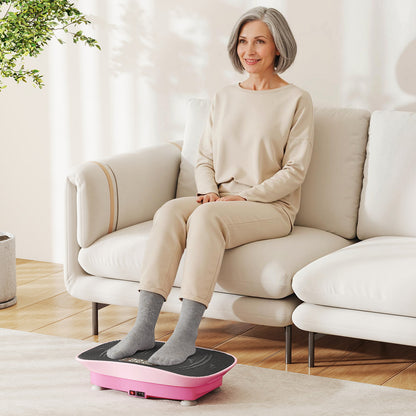 The exercise machine placed on a carpet with a woman sitting on a sofa and resting her feet on it