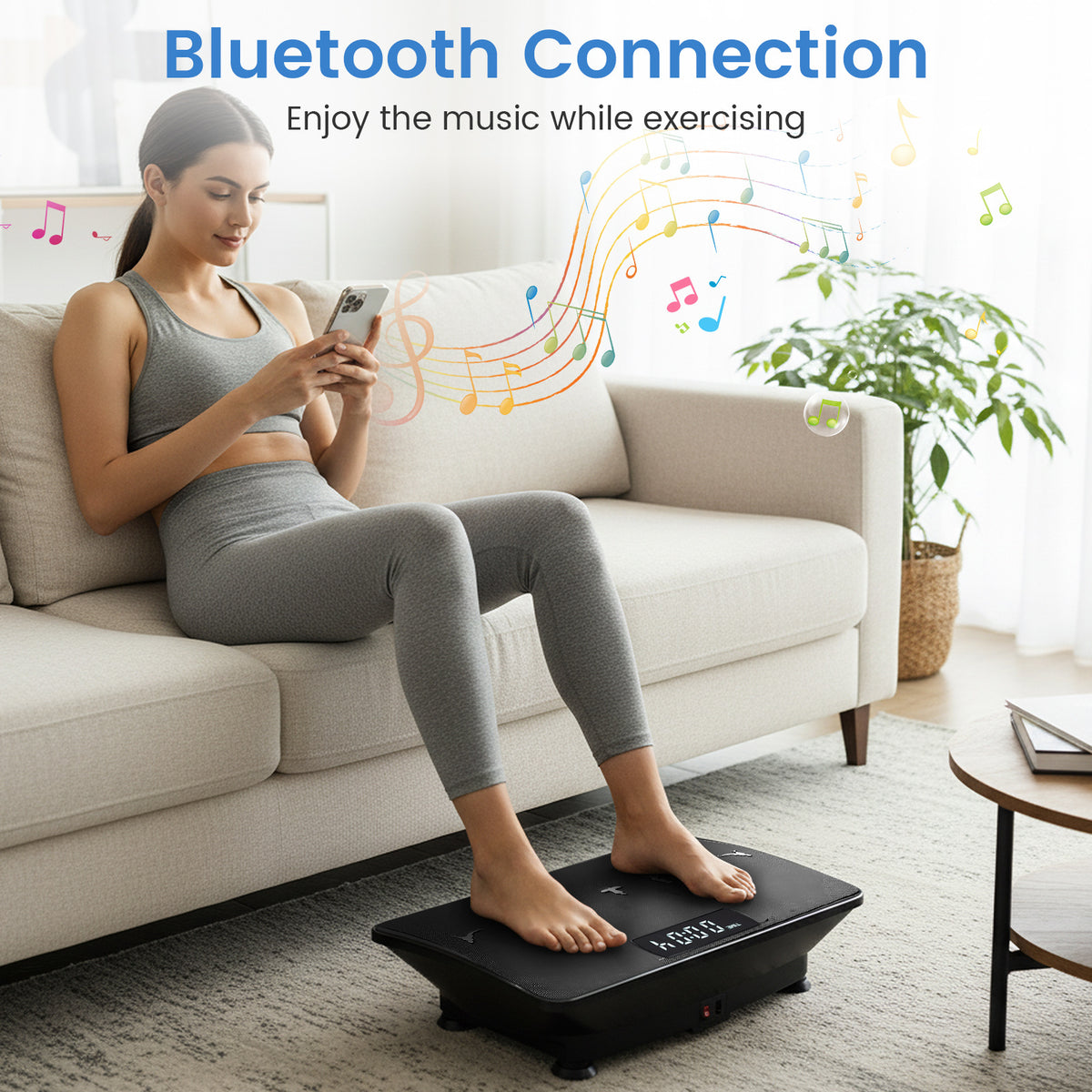 The exercise machine being used by a woman sitting on a sofa while using her mobile phone