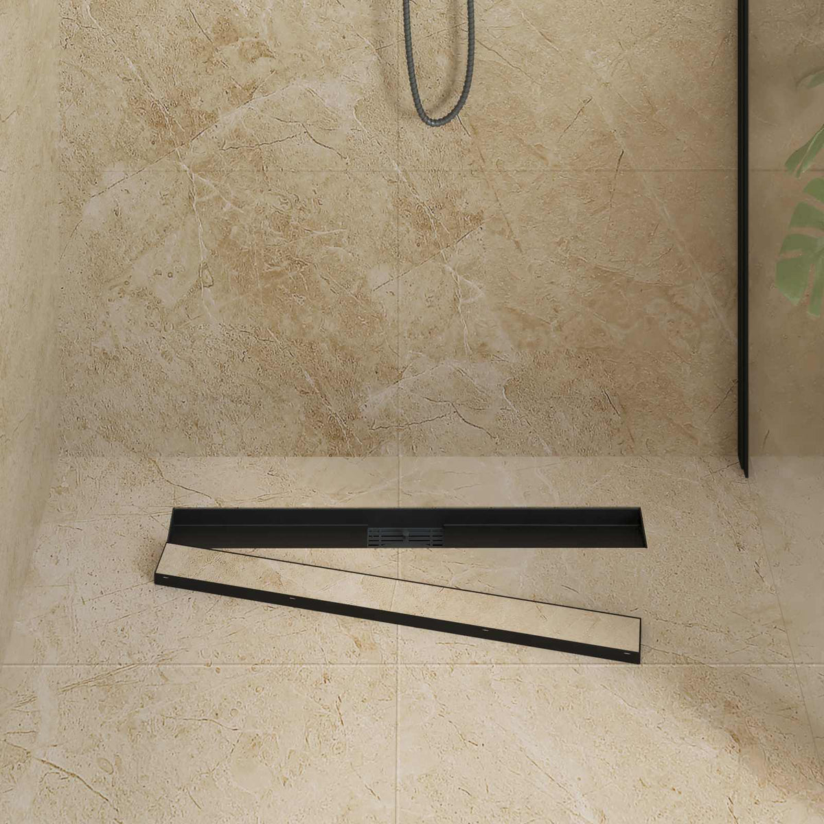 The black shower drain with its cover removed, showing the internal channel