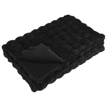 A folded black faux rabbit fur blanket showing its textured surface
