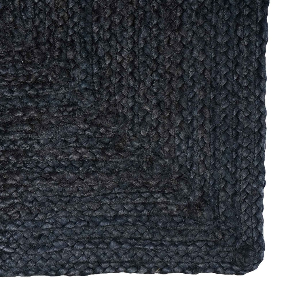 Close-up of the dark grey jute rug's corner and woven texture