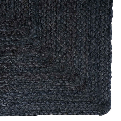 Close-up of the dark grey jute rug's corner and woven texture