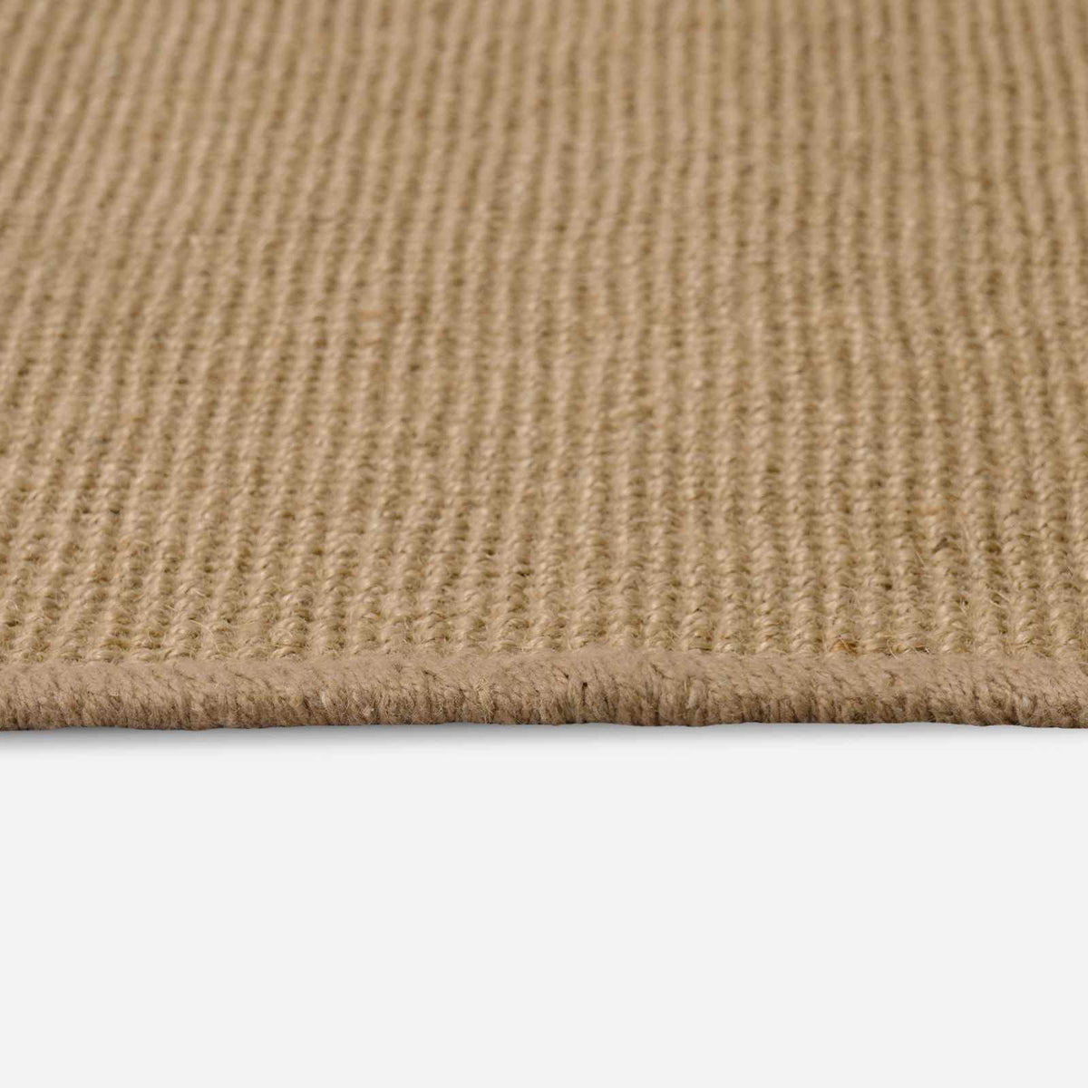 the natural jute rug showing its woven texture and edge