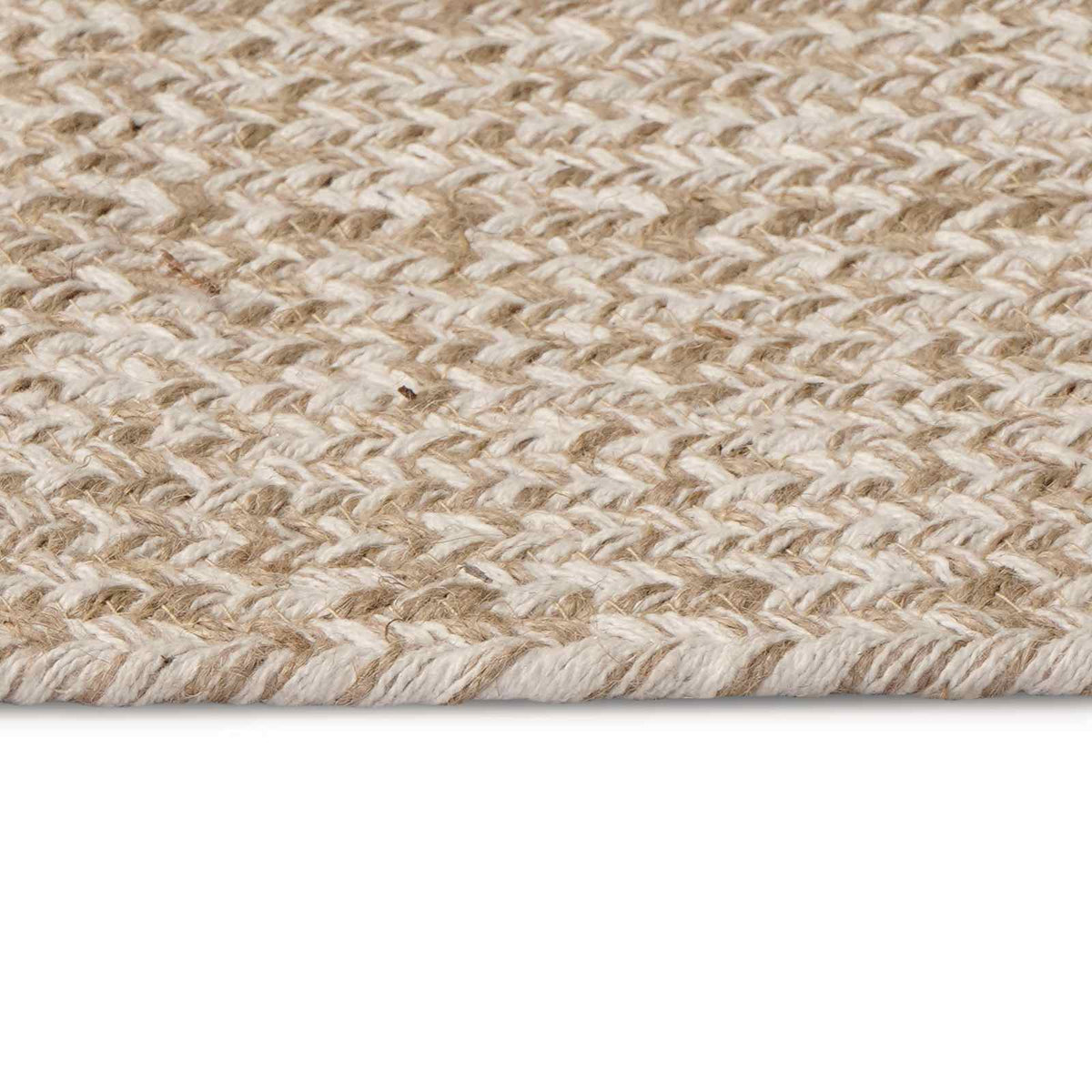 A close-up of the white jute rug's edge and woven texture, showing the material