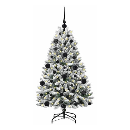 The artificial Christmas tree standing on its black metal base, decorated with baubles and lights