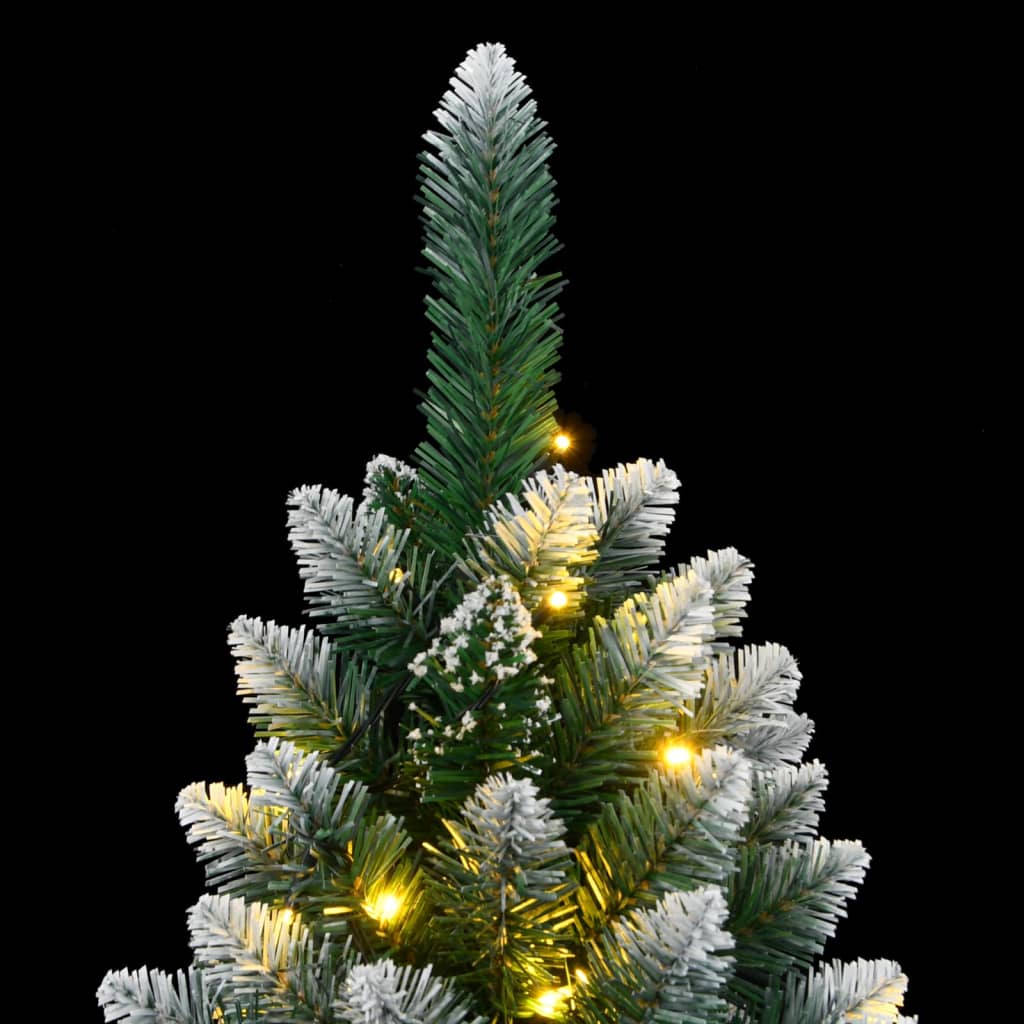The top section of the artificial christmas tree with snowy tips and glowing lights