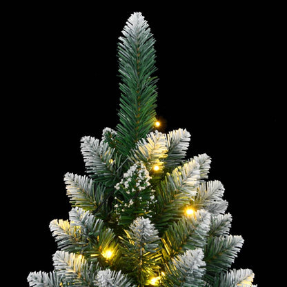 The top section of the artificial christmas tree with snowy tips and glowing lights