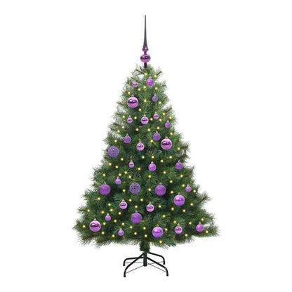 The green artificial Christmas tree, decorated with purple baubles and lights, standing on a black metal stand