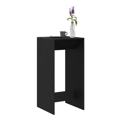 Black oak engineered wood bar table with a vase of flowers on top