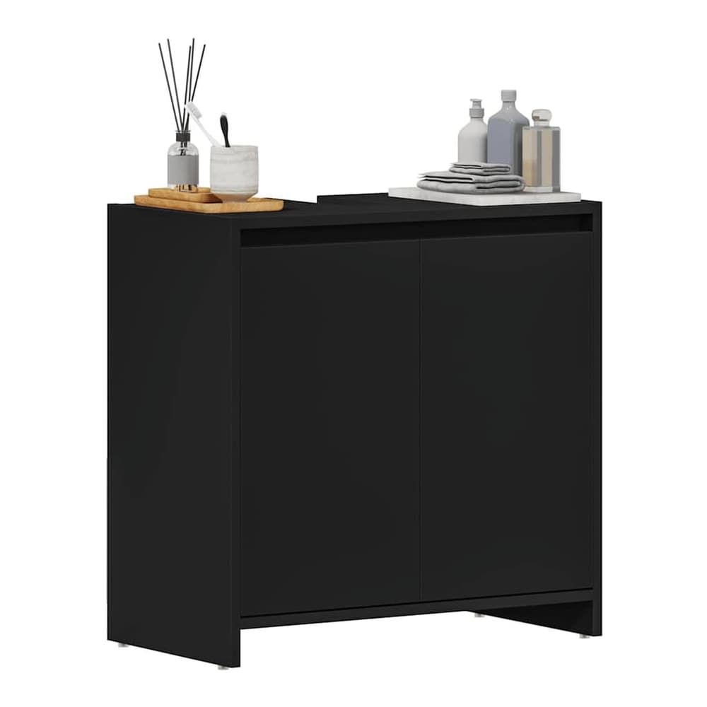 Black bathroom cabinet with items on top including bottles and a toothbrush holder