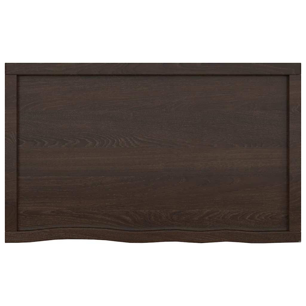The dark brown bathroom worktop seen from the front displaying the natural live edge detail