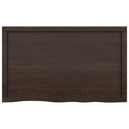 The dark brown bathroom worktop seen from the front displaying the natural live edge detail