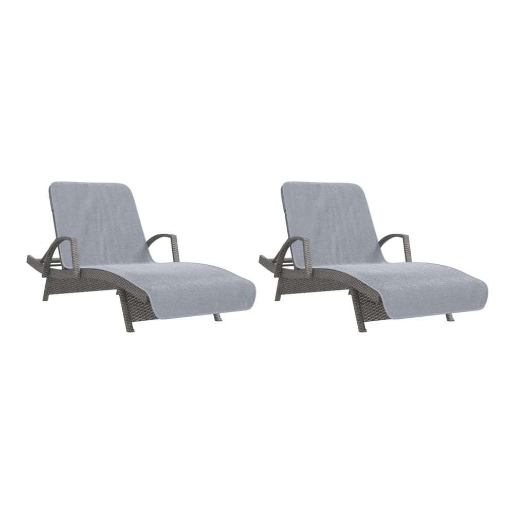 Two grey beach towels draped over two sun loungers outdoors