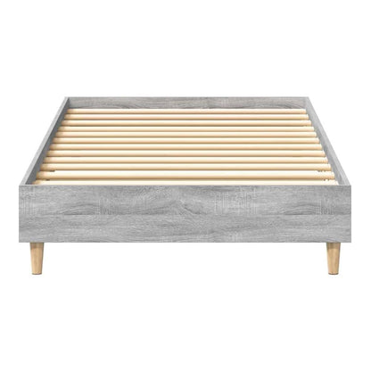 Close-up of the grey engineered wood bed frame, highlighting the slatted base and wooden legs