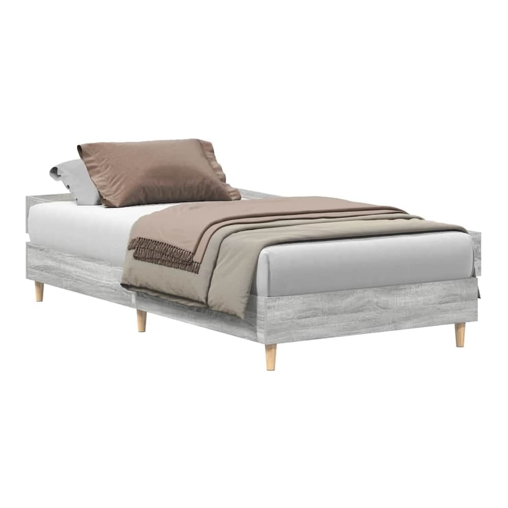 The grey engineered wood bed frame with a mattress and bedding, showing the side profile