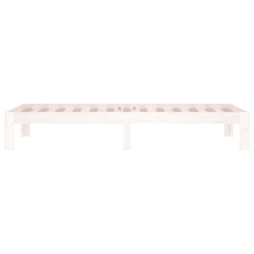 The white wooden bed frame without mattress is shown from a low side angle, emphasizing its structure