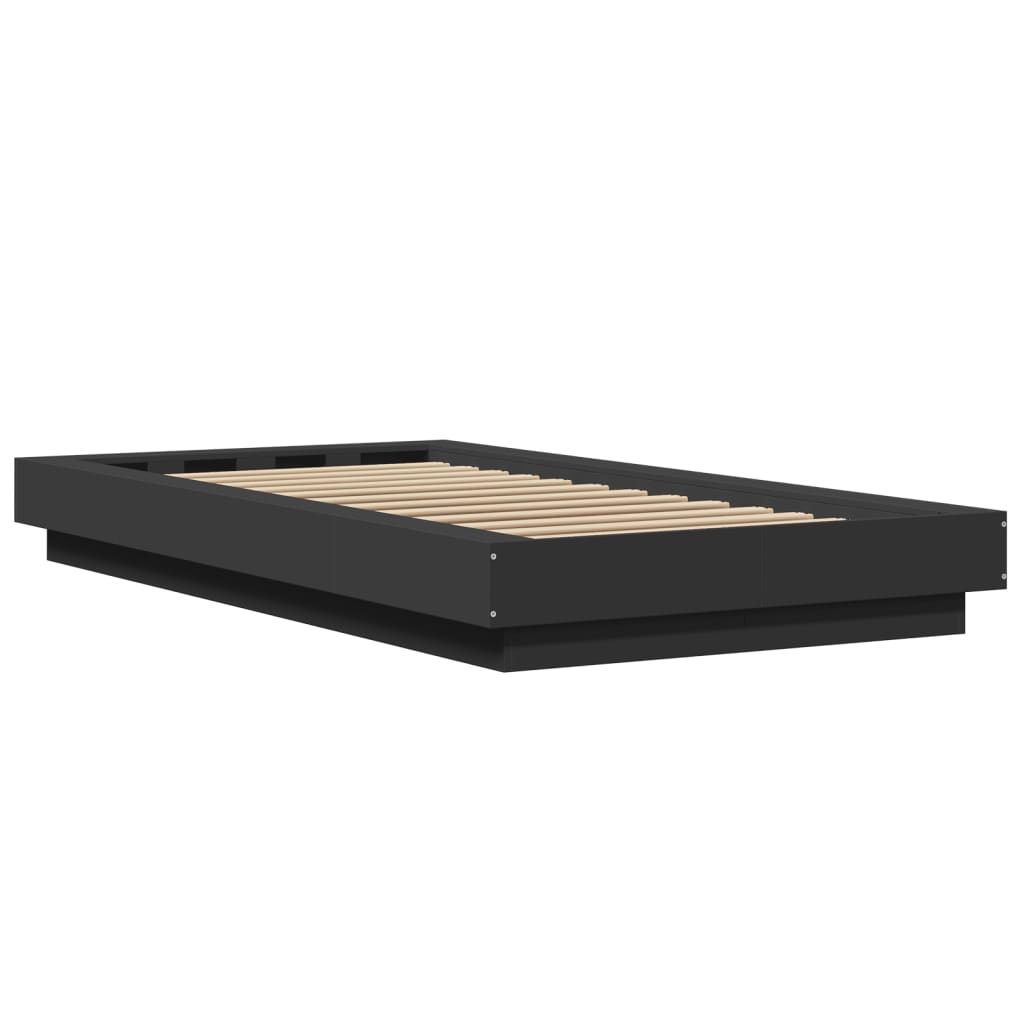 The black small single bed frame shown from a low angle with wooden slats visible