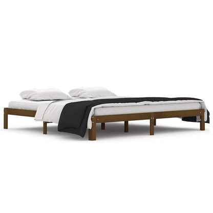 The honey brown wooden bed frame without a mattress, shown with bedding from the side