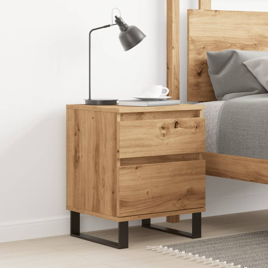The bedside table placed next to a bed with a lamp and book on top